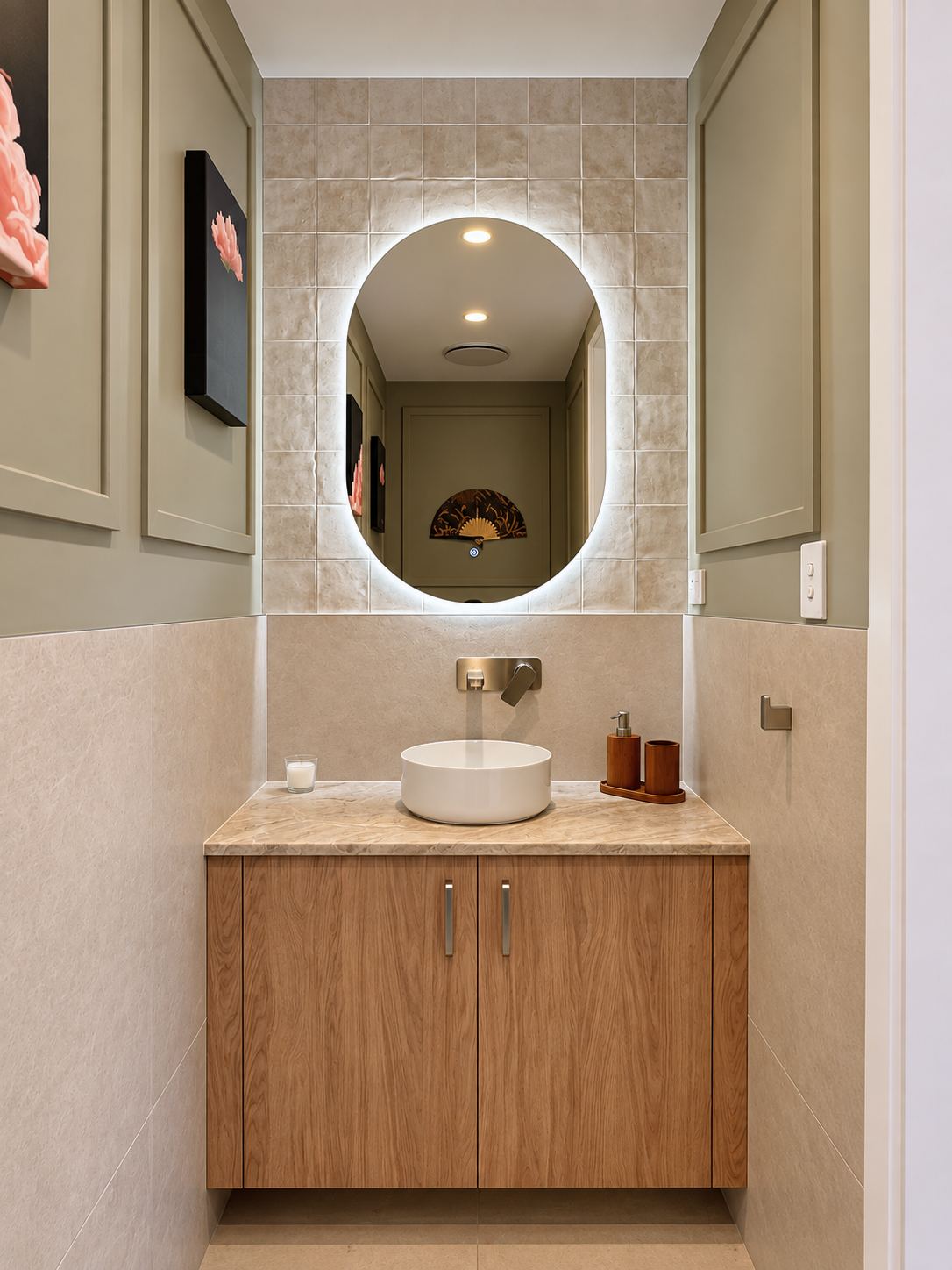 Powder room with backlit oval mirror and oak vanity